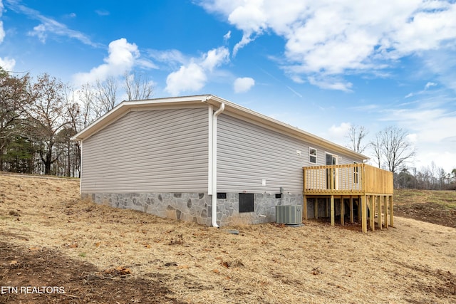 view of property exterior featuring central air condition unit and a deck