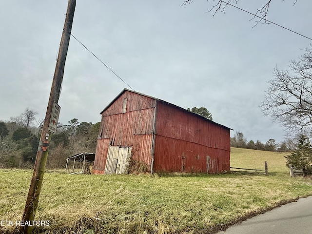 view of outbuilding featuring a rural view and a yard