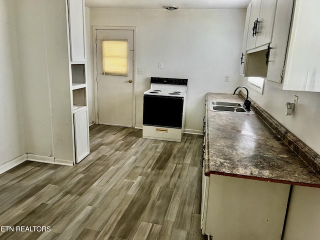 kitchen featuring white cabinets, hardwood / wood-style flooring, white electric stove, and sink