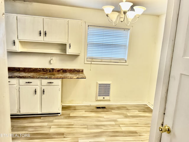 kitchen featuring white cabinets, a chandelier, and light hardwood / wood-style floors