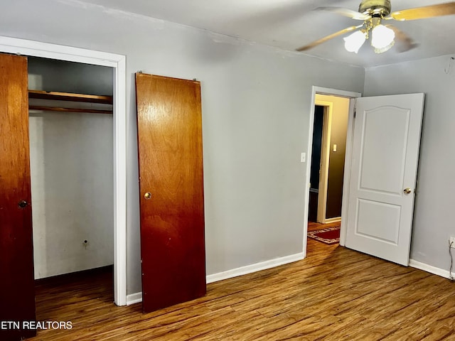 unfurnished bedroom with hardwood / wood-style flooring, ceiling fan, and a closet