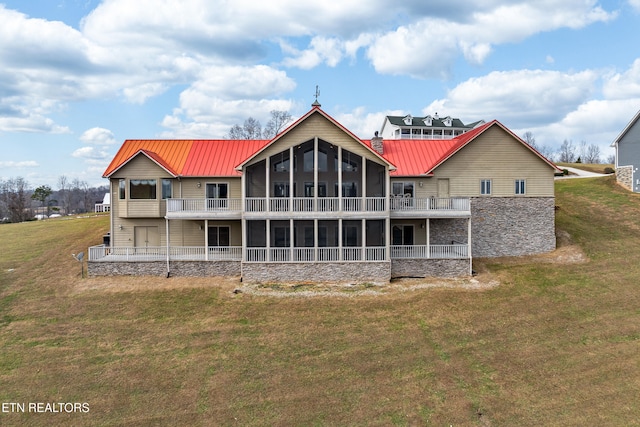 rear view of house featuring a yard and a sunroom