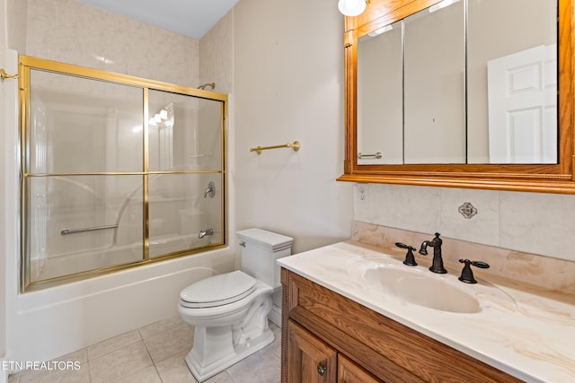 full bathroom with vanity, bath / shower combo with glass door, tile patterned flooring, toilet, and tasteful backsplash