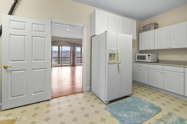 kitchen featuring white appliances, light hardwood / wood-style flooring, and white cabinetry