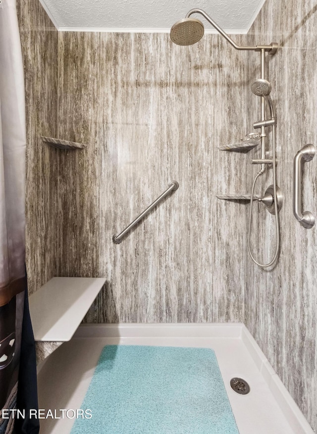 bathroom featuring a tile shower and a textured ceiling