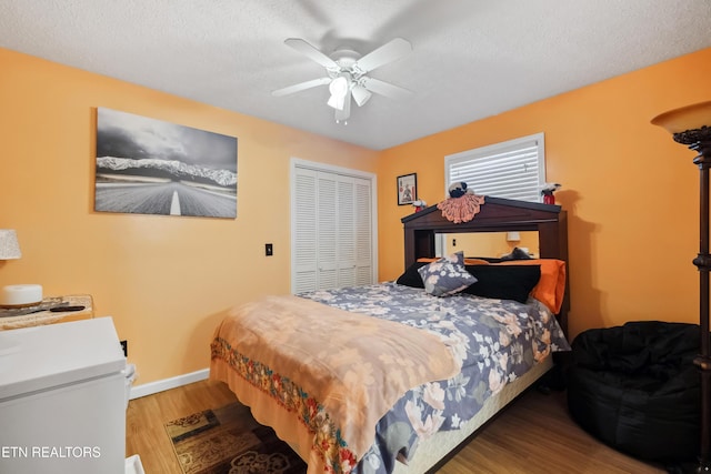 bedroom featuring a closet, ceiling fan, hardwood / wood-style floors, and a textured ceiling