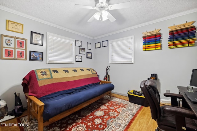 office space featuring wood-type flooring, a textured ceiling, ceiling fan, and ornamental molding