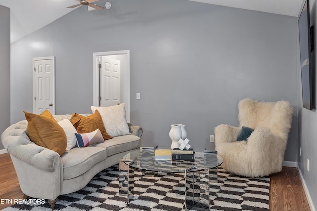 living room featuring hardwood / wood-style flooring, ceiling fan, and vaulted ceiling