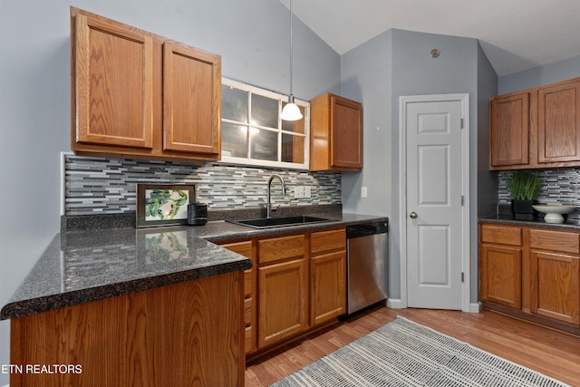 kitchen with decorative backsplash, dishwasher, hanging light fixtures, and sink