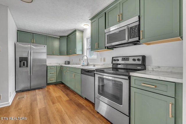 kitchen featuring sink, stainless steel appliances, and green cabinetry