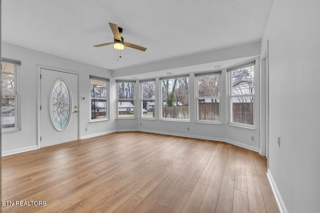 interior space with light wood-type flooring, ceiling fan, and a healthy amount of sunlight