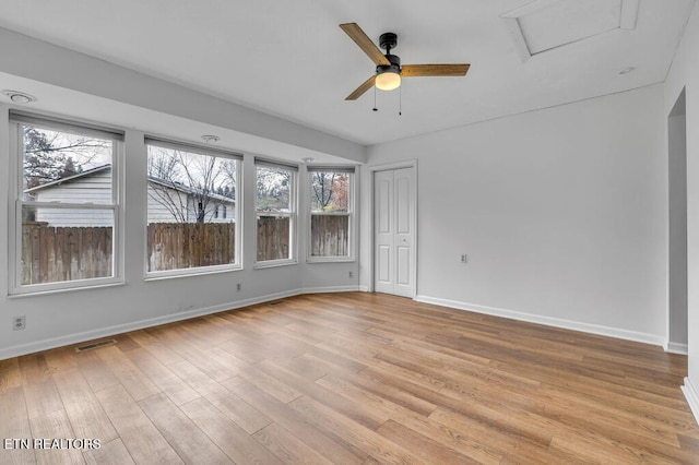 empty room with light wood-type flooring, plenty of natural light, and ceiling fan