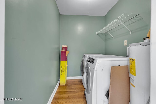 laundry room featuring washing machine and clothes dryer, light wood-type flooring, and water heater