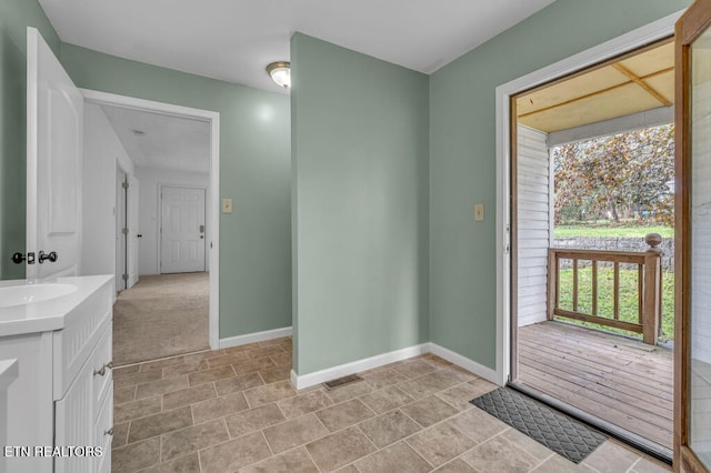 doorway to outside featuring sink and light colored carpet