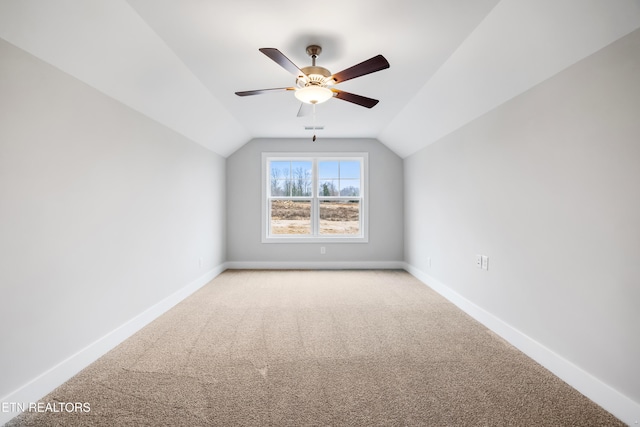 additional living space featuring ceiling fan, light colored carpet, and vaulted ceiling