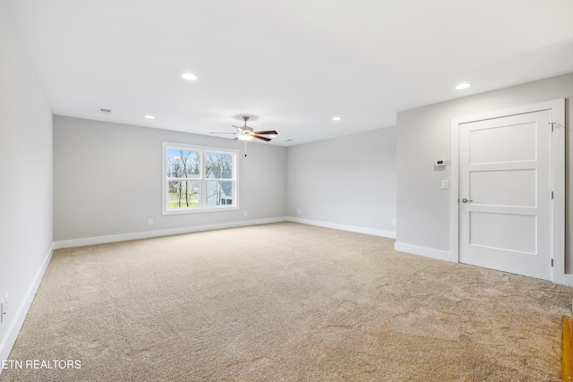 carpeted spare room featuring ceiling fan