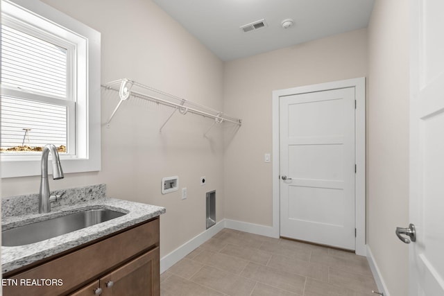 washroom with cabinets, sink, hookup for a washing machine, light tile patterned floors, and hookup for an electric dryer