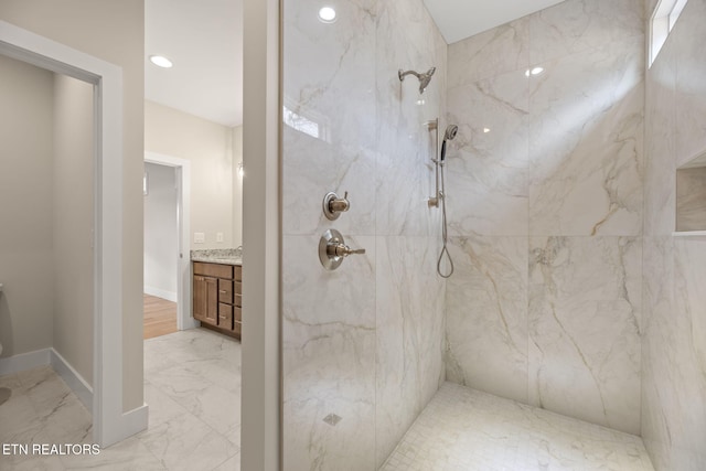 bathroom featuring tiled shower and vanity