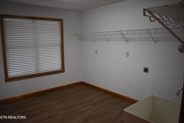 clothes washing area featuring hookup for an electric dryer and dark wood-type flooring