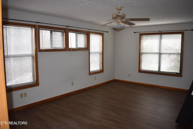 unfurnished room featuring dark hardwood / wood-style floors, ceiling fan, and a textured ceiling