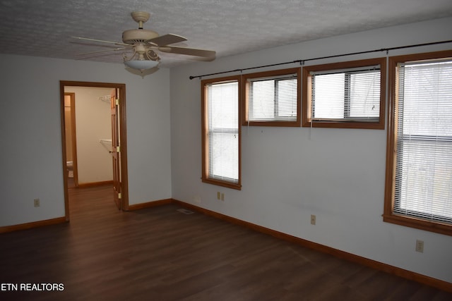 empty room featuring a textured ceiling, dark hardwood / wood-style flooring, and ceiling fan