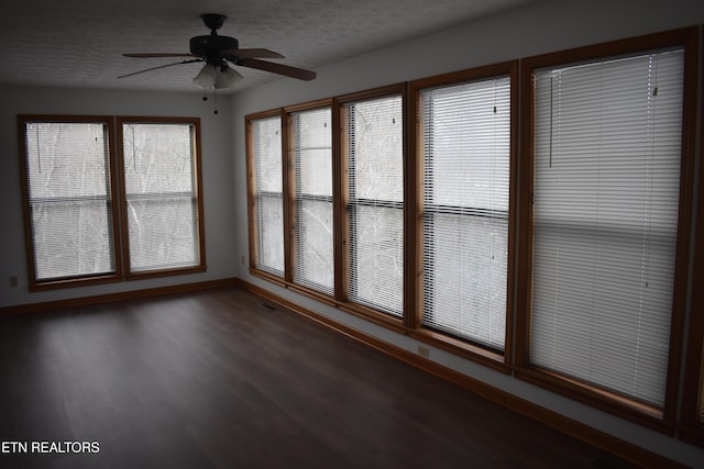 unfurnished sunroom with ceiling fan