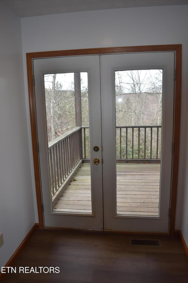 doorway with a healthy amount of sunlight, dark wood-type flooring, and french doors