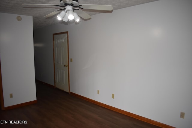 empty room with dark hardwood / wood-style flooring, a textured ceiling, and ceiling fan