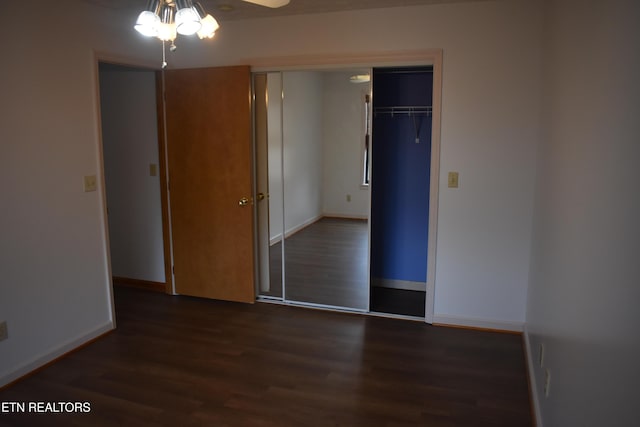 unfurnished bedroom featuring dark hardwood / wood-style floors, ceiling fan, and a closet