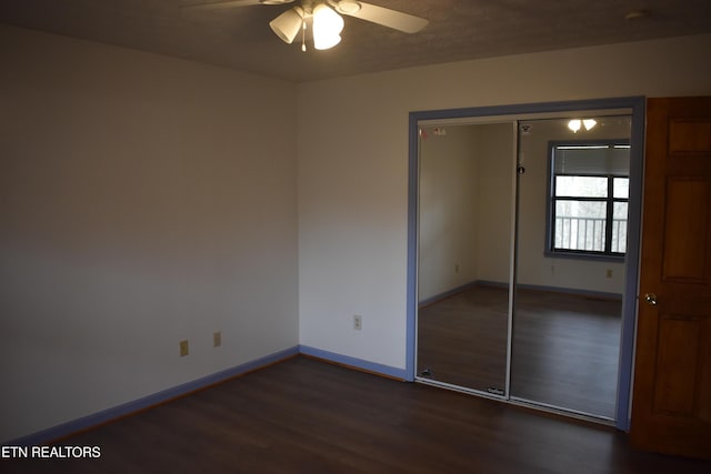 unfurnished bedroom featuring a closet, ceiling fan, and dark wood-type flooring