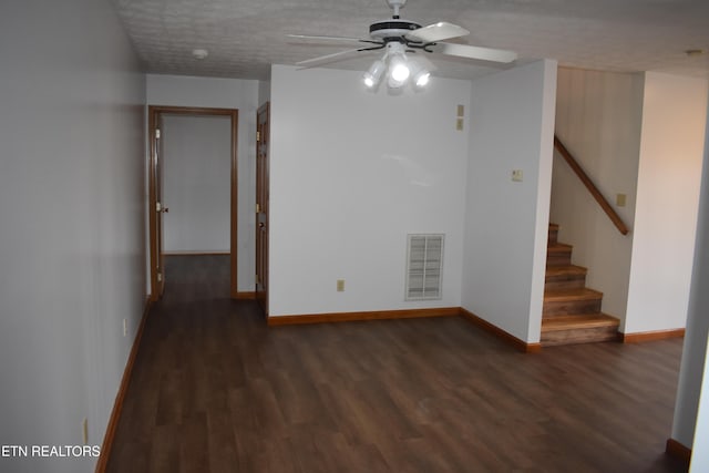 empty room with a textured ceiling, ceiling fan, and dark wood-type flooring