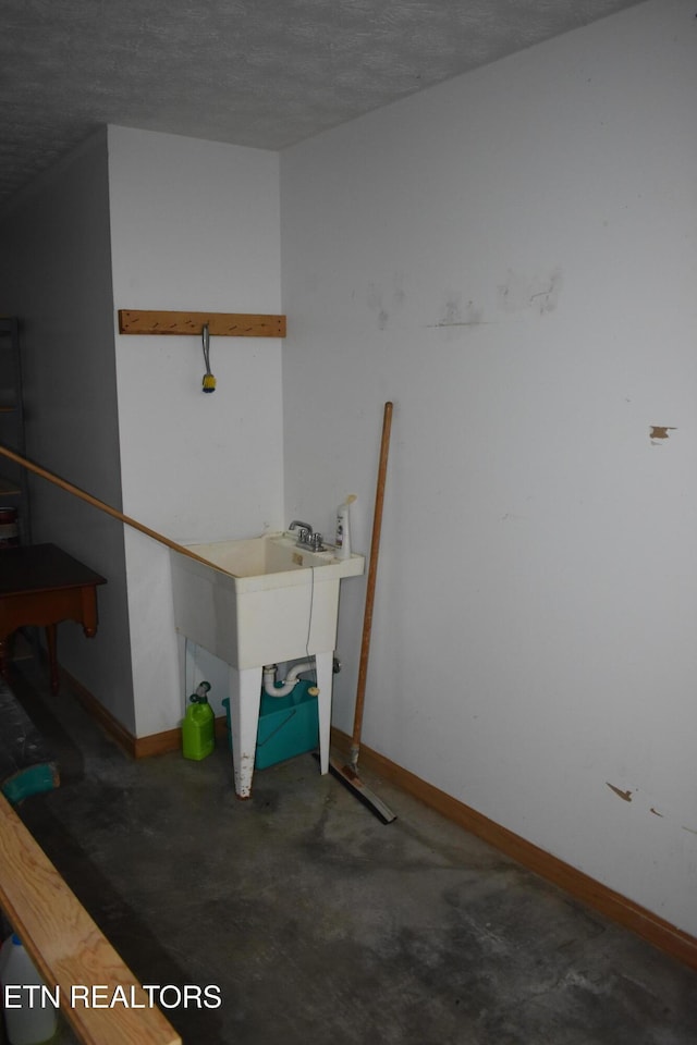 clothes washing area with a textured ceiling