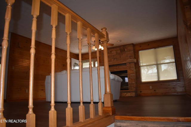 stairs featuring a fireplace, wood-type flooring, and a healthy amount of sunlight