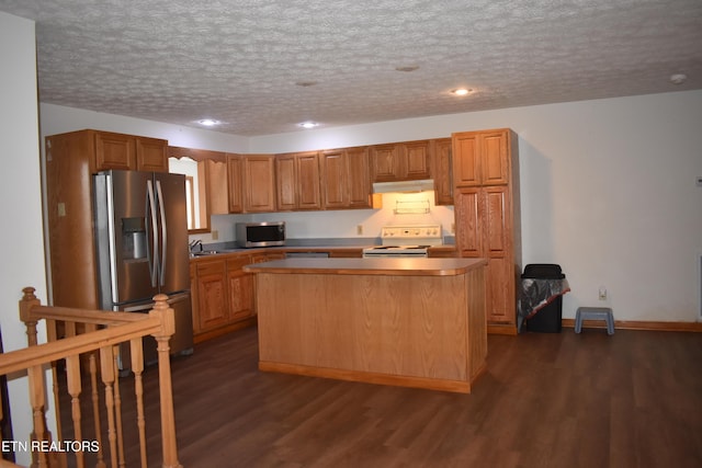 kitchen with a textured ceiling, a center island, dark hardwood / wood-style floors, and appliances with stainless steel finishes