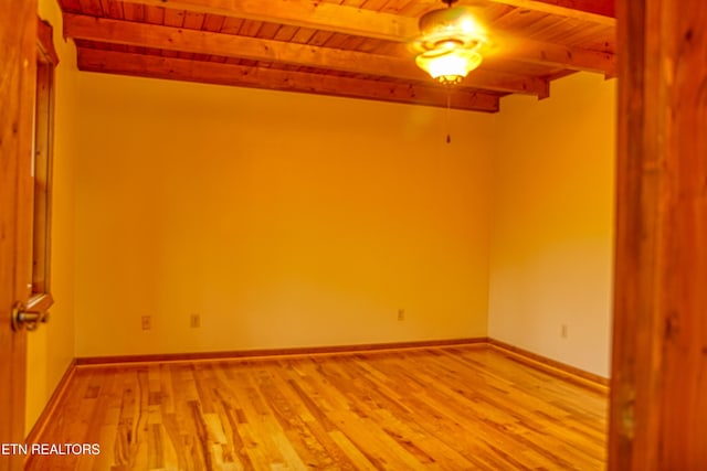 spare room with beam ceiling, light hardwood / wood-style flooring, and wooden ceiling