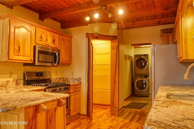 kitchen featuring beam ceiling, sink, wooden ceiling, stacked washer / dryer, and appliances with stainless steel finishes