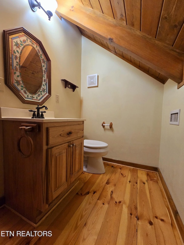 bathroom with beam ceiling, wooden ceiling, hardwood / wood-style floors, toilet, and vanity