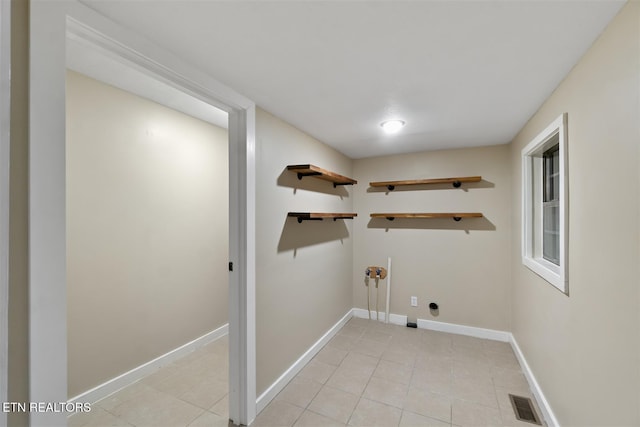 laundry area with electric dryer hookup, light tile patterned floors, and washer hookup