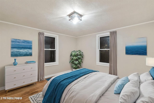 bedroom with crown molding, hardwood / wood-style floors, and a textured ceiling