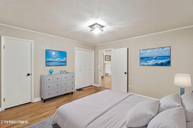 bedroom with light hardwood / wood-style floors, crown molding, and a textured ceiling