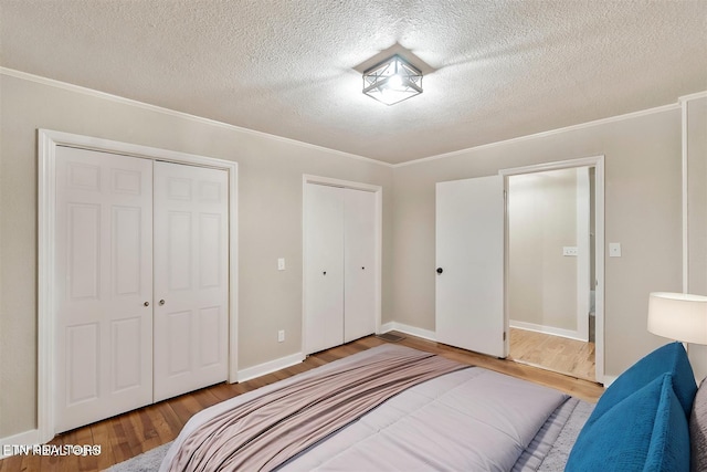 bedroom featuring ornamental molding, a textured ceiling, and hardwood / wood-style flooring