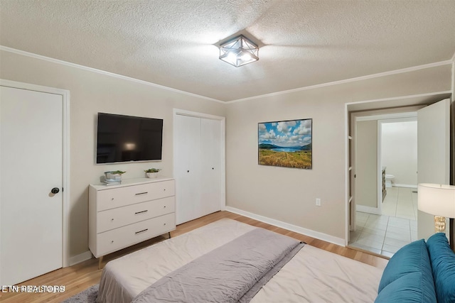 bedroom with a closet, crown molding, a textured ceiling, and light hardwood / wood-style flooring