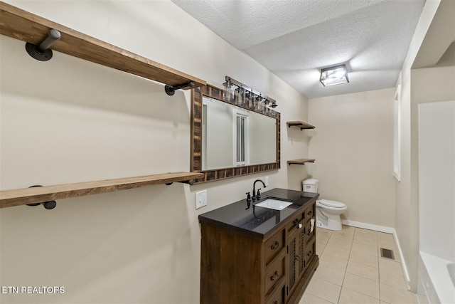 bathroom featuring tile patterned floors, vanity, toilet, and a textured ceiling