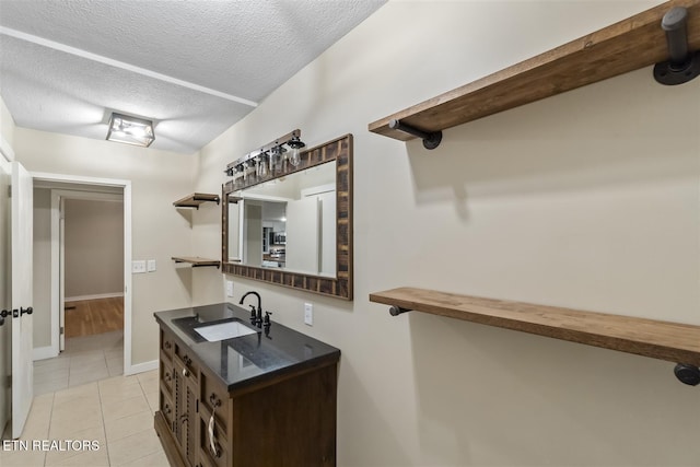 bathroom featuring tile patterned floors, vanity, and a textured ceiling