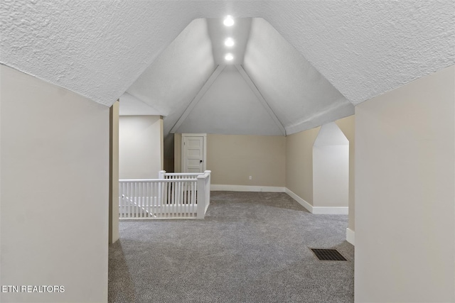 bonus room featuring carpet, a textured ceiling, and vaulted ceiling