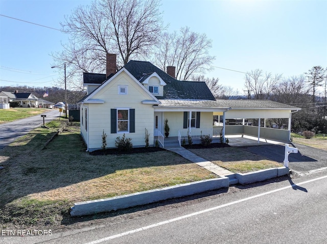 view of front of property with a carport, covered porch, and a front yard