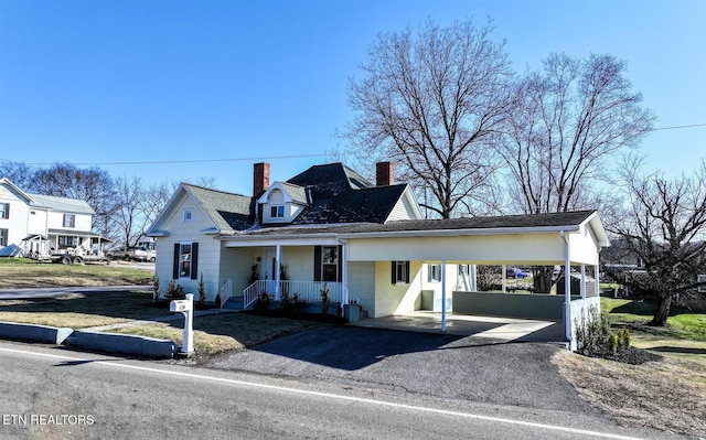 view of front facade featuring covered porch and a carport