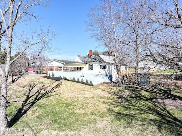 back of house with a sunroom and a lawn