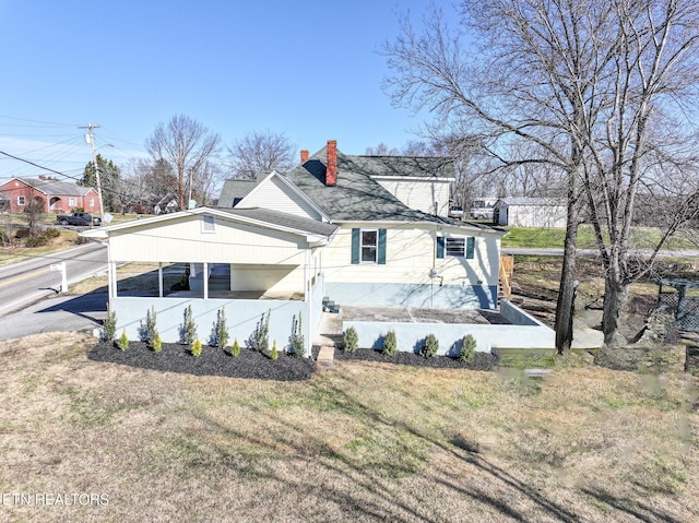 view of front of property featuring a front yard and a carport