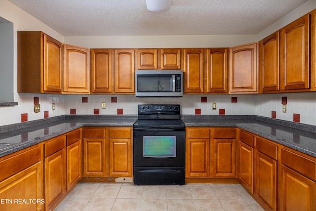 kitchen with a textured ceiling, light tile patterned floors, backsplash, and black / electric stove